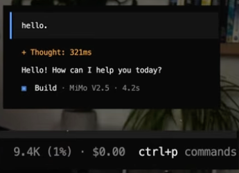 An OpenCode terminal after a one-word 'hello' prompt: the model has already replied 'Hello! How can I help you today?' and the status bar reads 9.4K tokens.